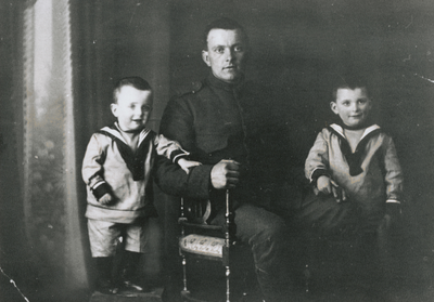 875939 Portret van vader Verweij in militair uniform, met zijn zoontjes Niek (links) en Cornelis, uit Wijk C te ...